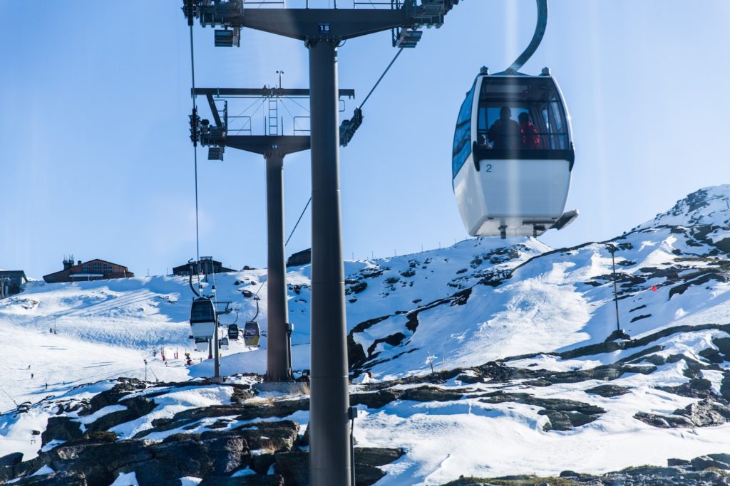 snowy mountain landscape where cable carts are seen in the centre 