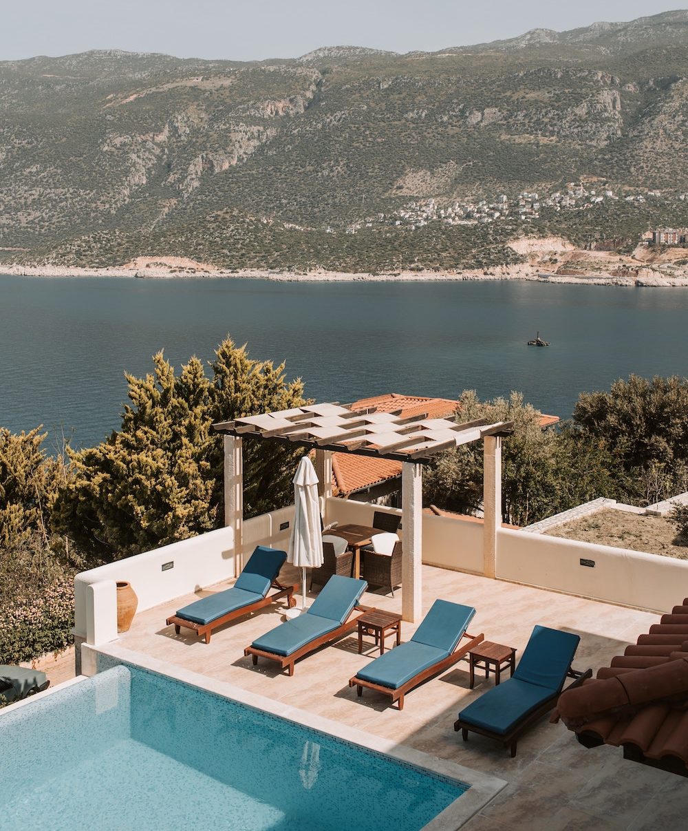 outdoor greek villa pool, overlooking the blue sea water.
