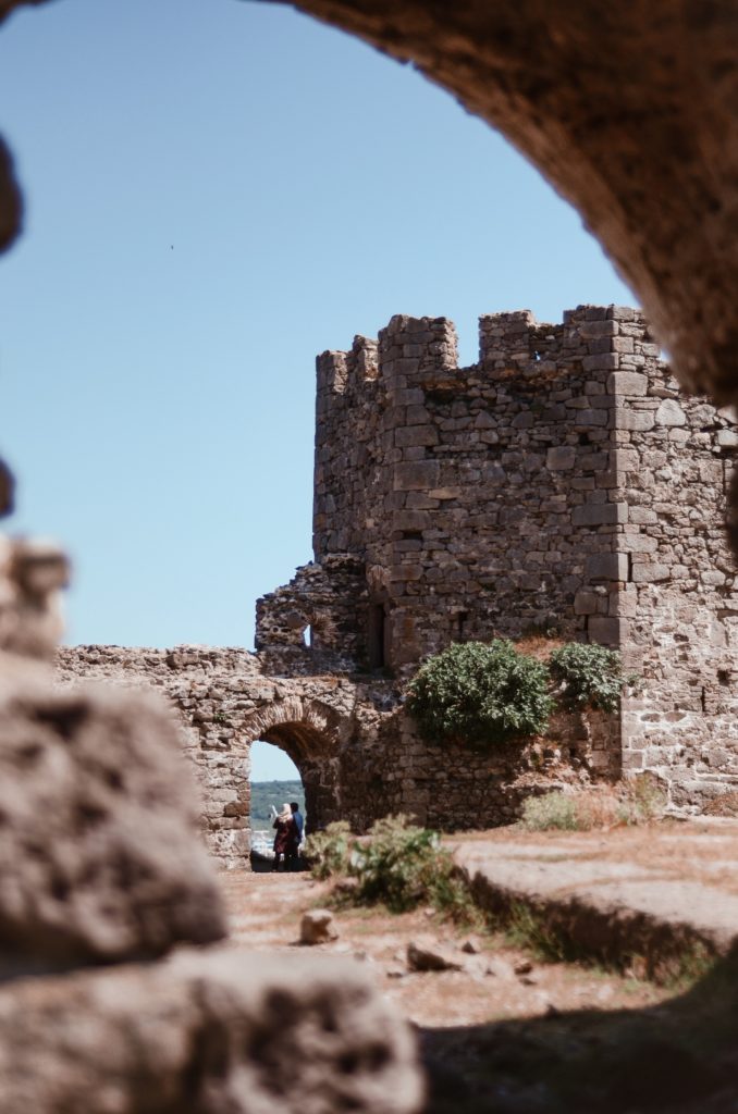 The ruins of an historical fortress with the sea visible through an archway.