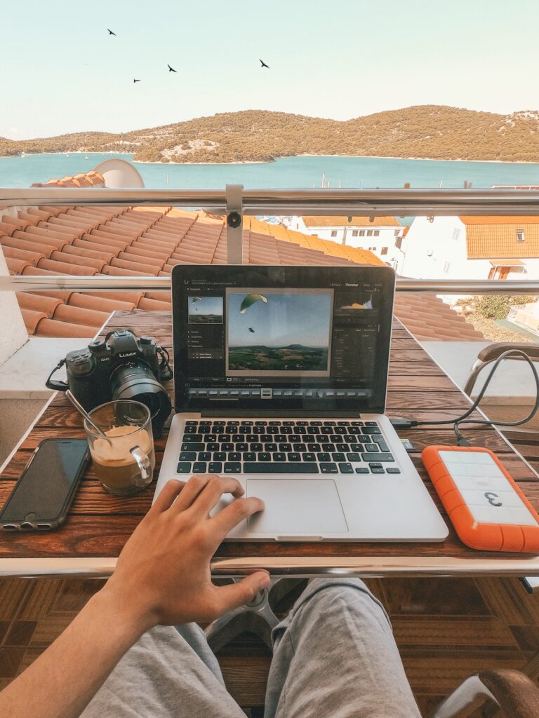 a work set up on a balcony with a view of the azure sea.