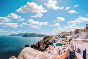 View of iconic whitewashed buildings with blue roofs in Santorini.