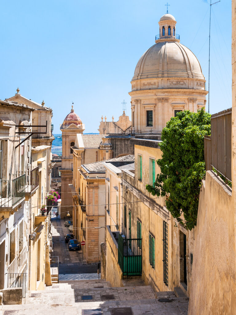 Noto, city walkway in Sicily Italy on a sunny day with bright blue skies.
