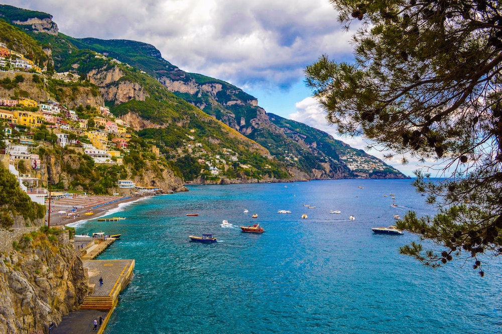 italian cliff landscape overlooking the sea with fishing boats docked